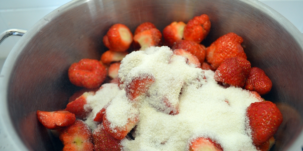 Gerüstete Erdbeeren mit Zucker in der Pfanne
