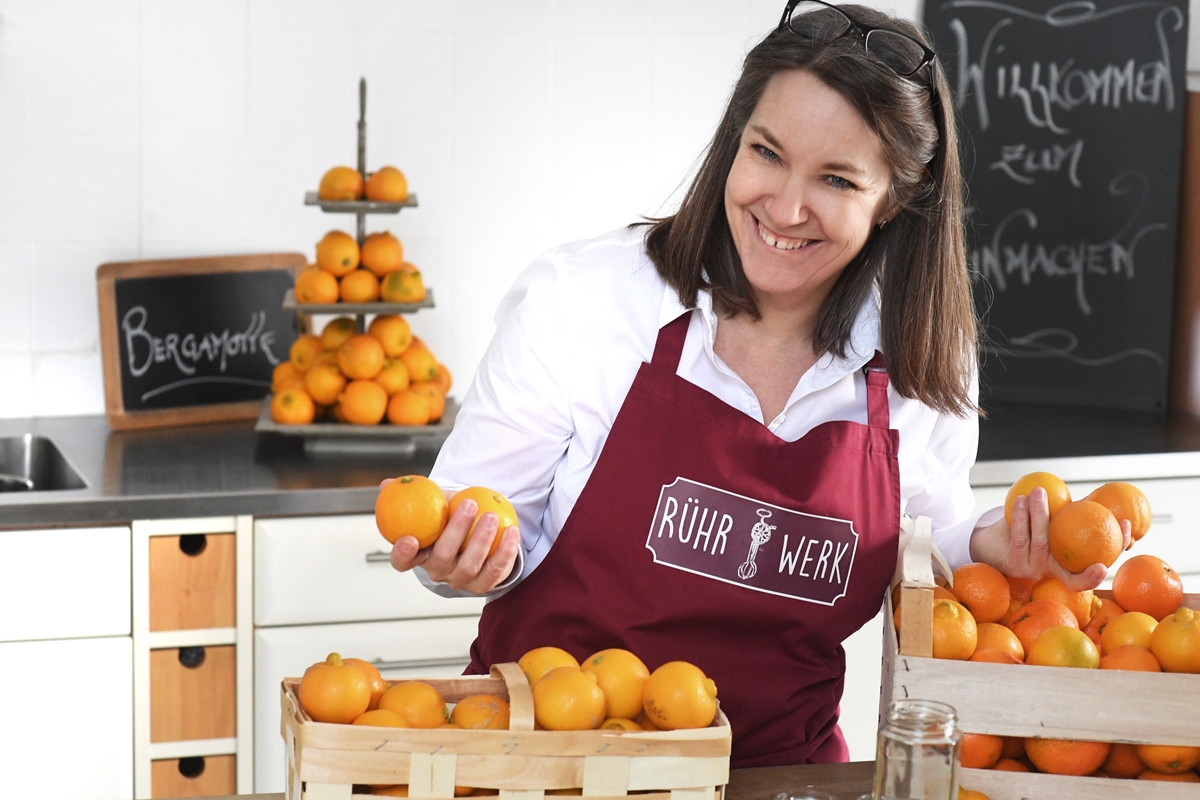 Karin Eggenberger alias Frau Rührwerk in der Küche. Auf dem Tisch verschiedene Zitrusfrüchte.